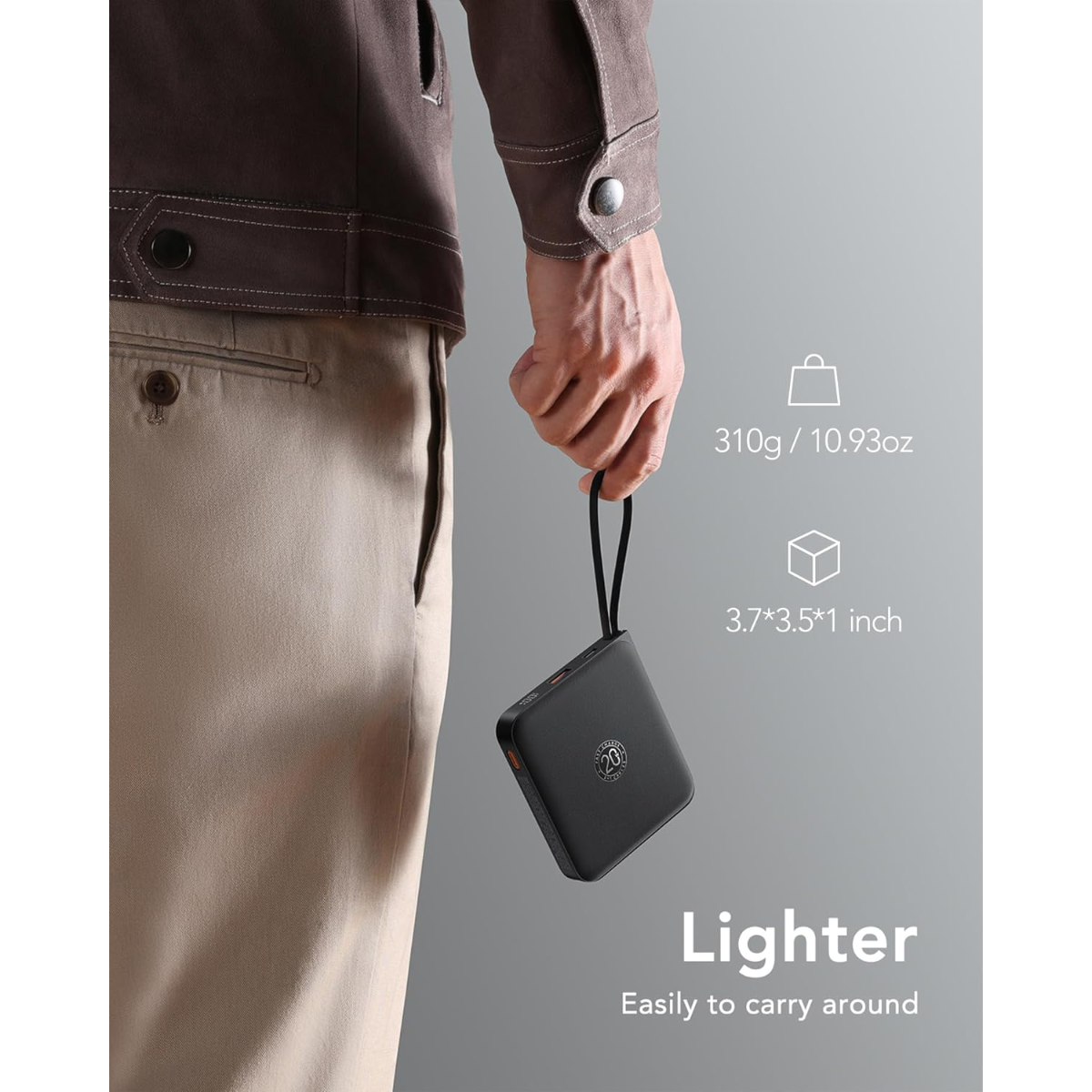 Ein Mann hält einen schwarzen, kompakten Powerbank mit einer Handschlaufe.
