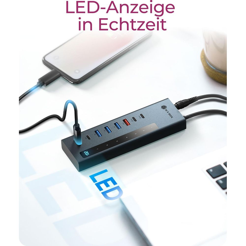 Ein schwarzer USB-Hub mit mehreren Anschlüssen, der an ein Smartphone und einen Laptop angeschlossen ist.