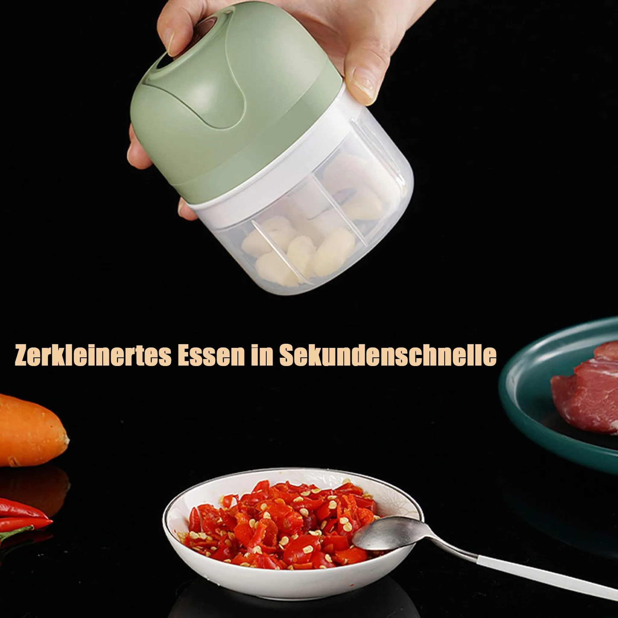 Grüner Mini-Zerkleinerer mit Knoblauch und Zutaten für Kochen.