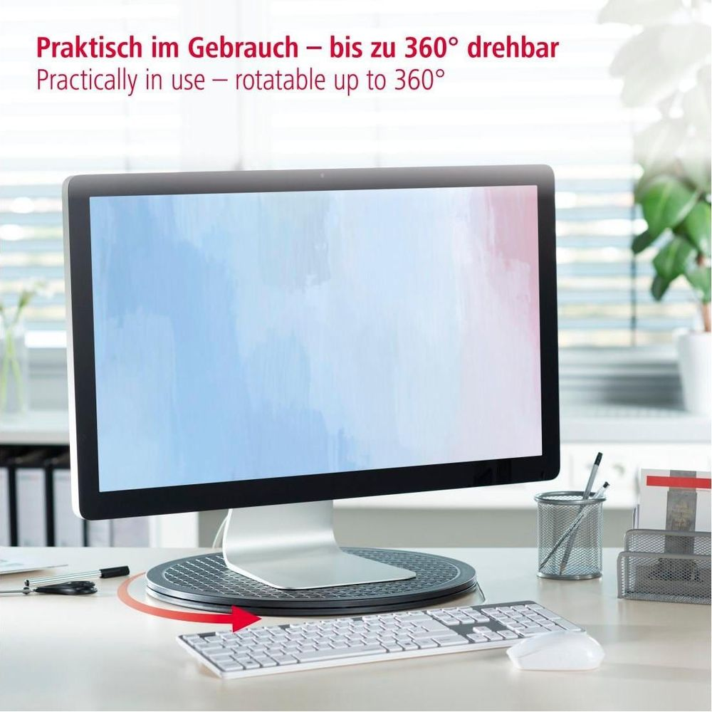 Ein Monitor steht auf einem Drehteller neben einer Tastatur und Maus.