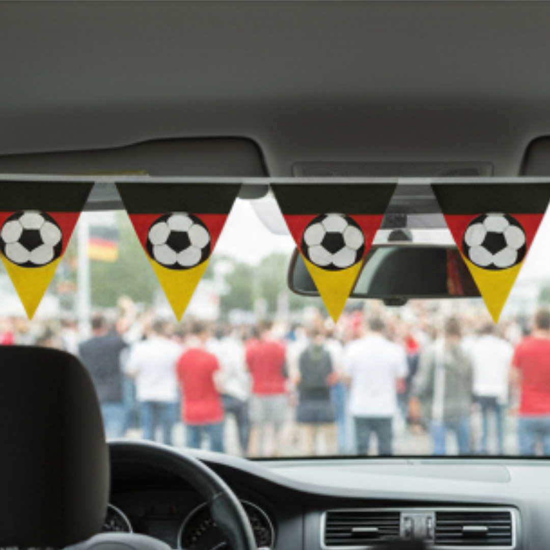 Wimpelkette in deutschen Flaggenfarben mit Fußbällen hängt im Auto, Blick auf Menge.