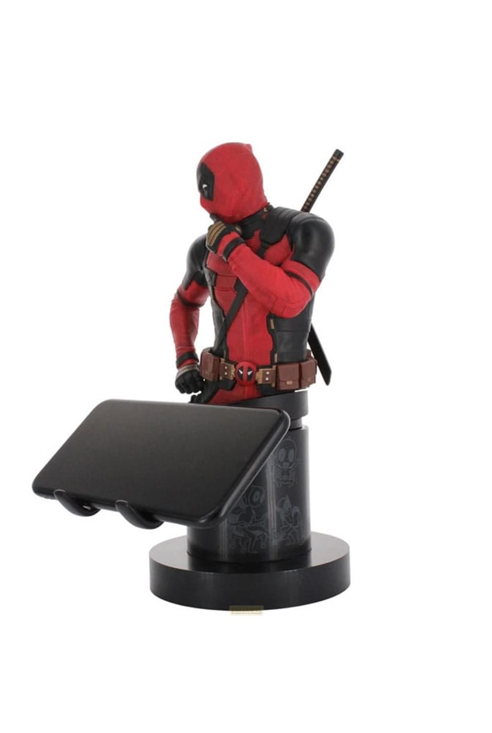 Figura de Deadpool sosteniendo un smartphone en un soporte negro con calaveras.