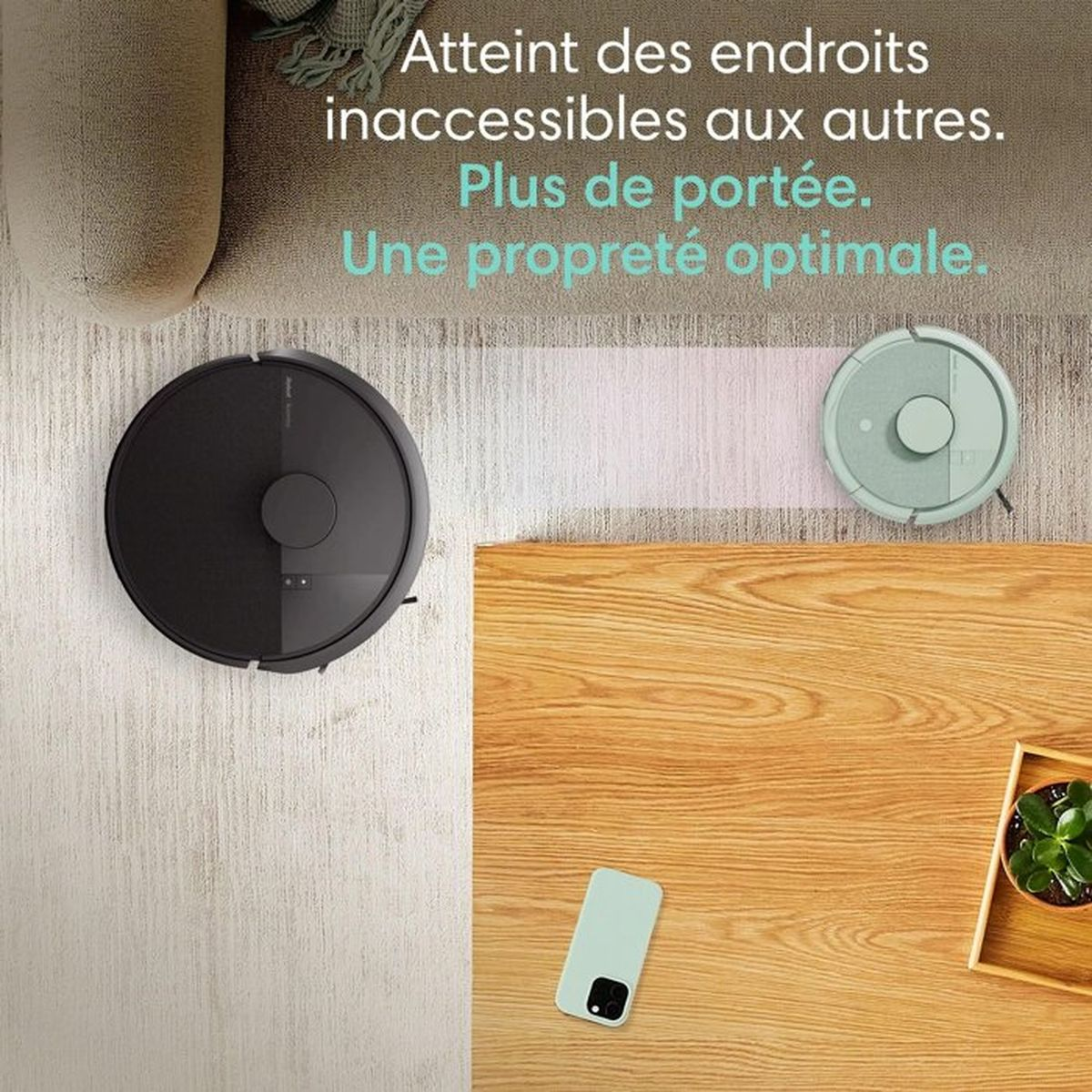 Due robot aspirapolvere su tappeto e tavolo di legno.