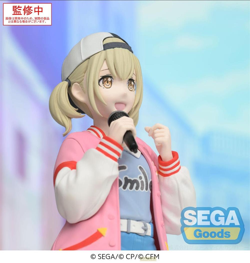 Eine Figur mit blonden Zöpfen, die ein Mikrofon hält, trägt eine rosa Jacke.