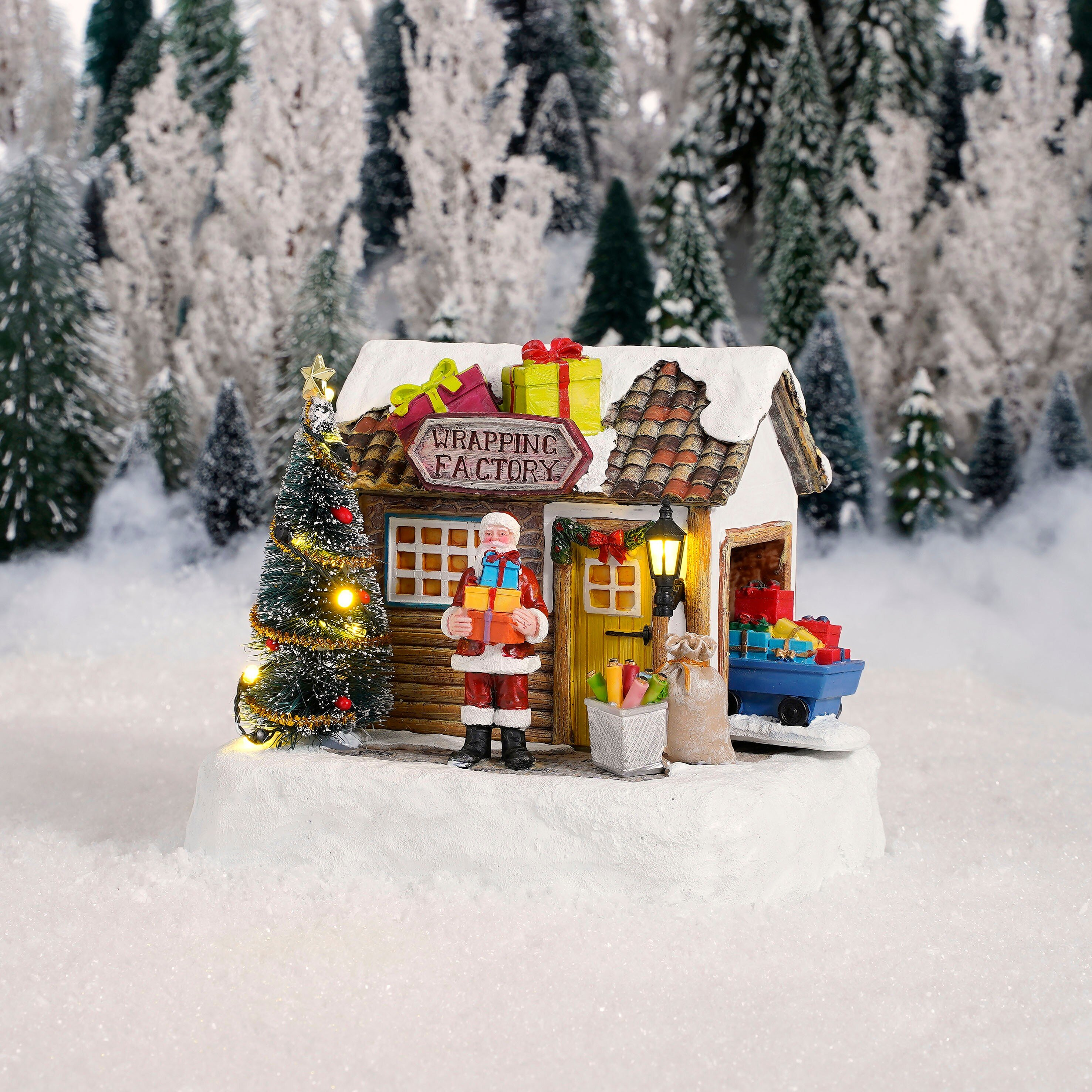Kerstman met cadeaus voor een fabriek met bomen in de sneeuw.
