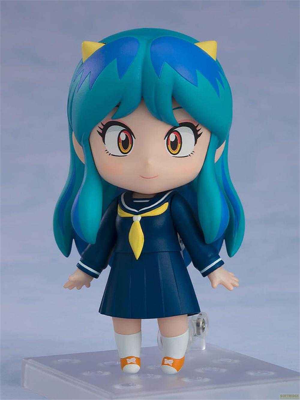 Figura de anime con pelo azul y cuernos amarillos, vestida de uniforme escolar.