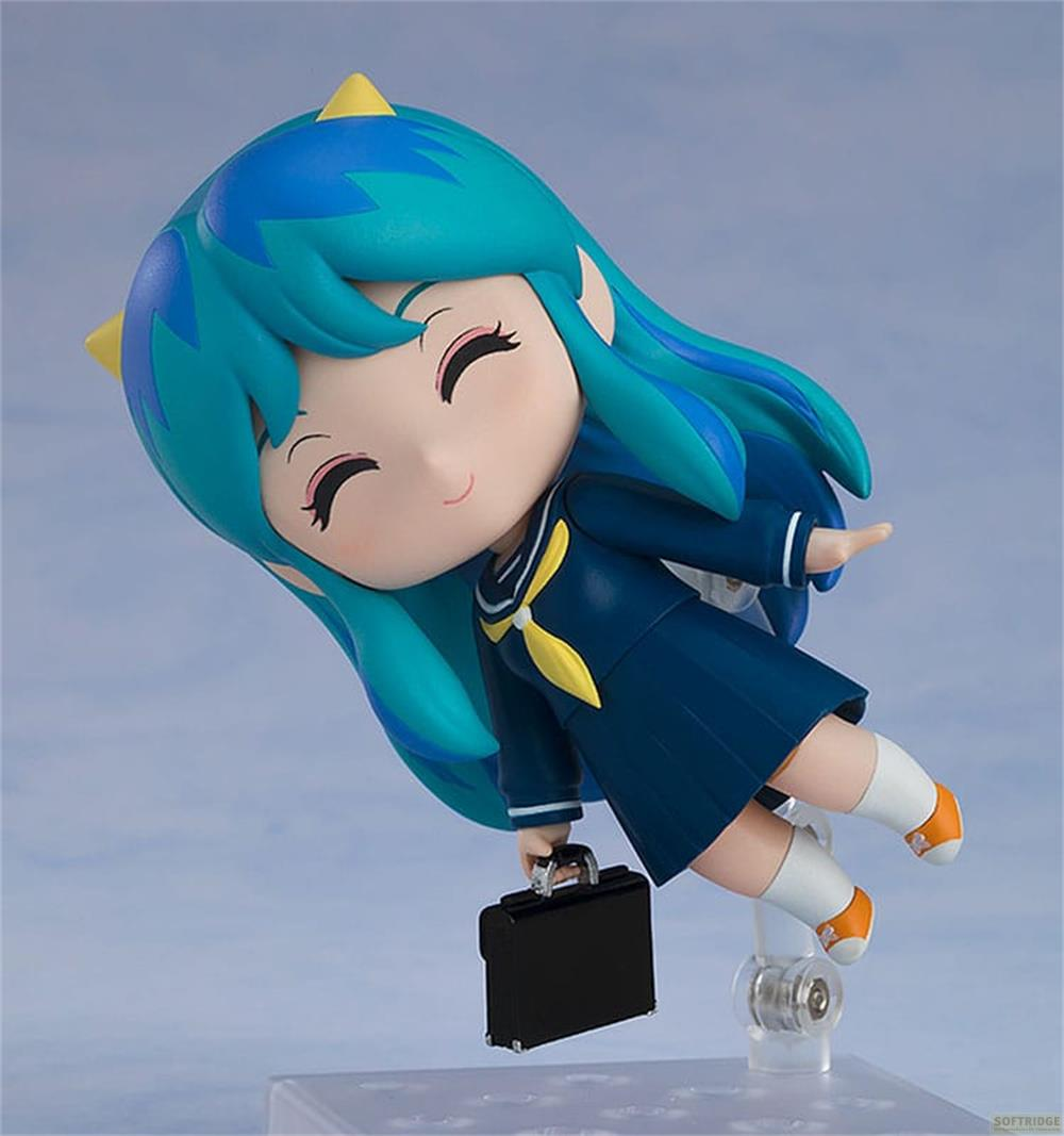 Una figura de anime con pelo azul y uniforme escolar sostiene un maletín.
