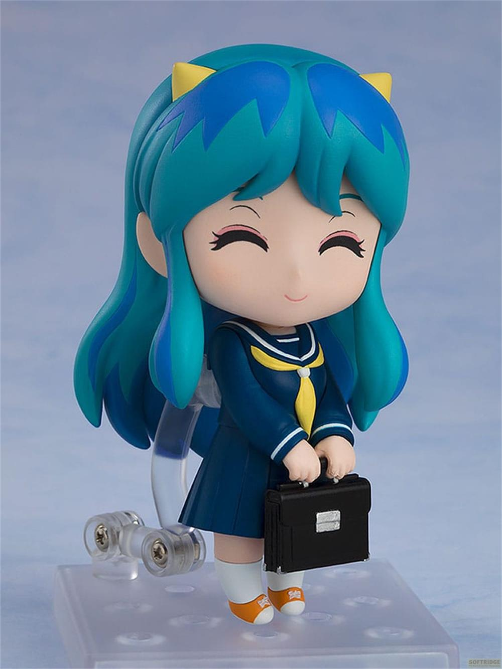 Figura de anime con pelo azul-verde lleva uniforme escolar, sosteniendo un maletín.