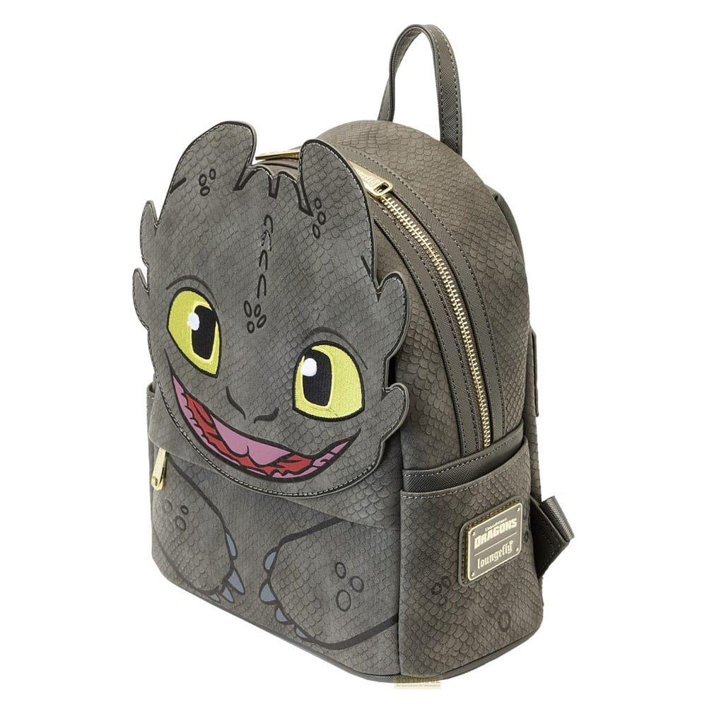 Una mochila gris con cara de dragón sonriente, ojos amarillos y boca rosa.