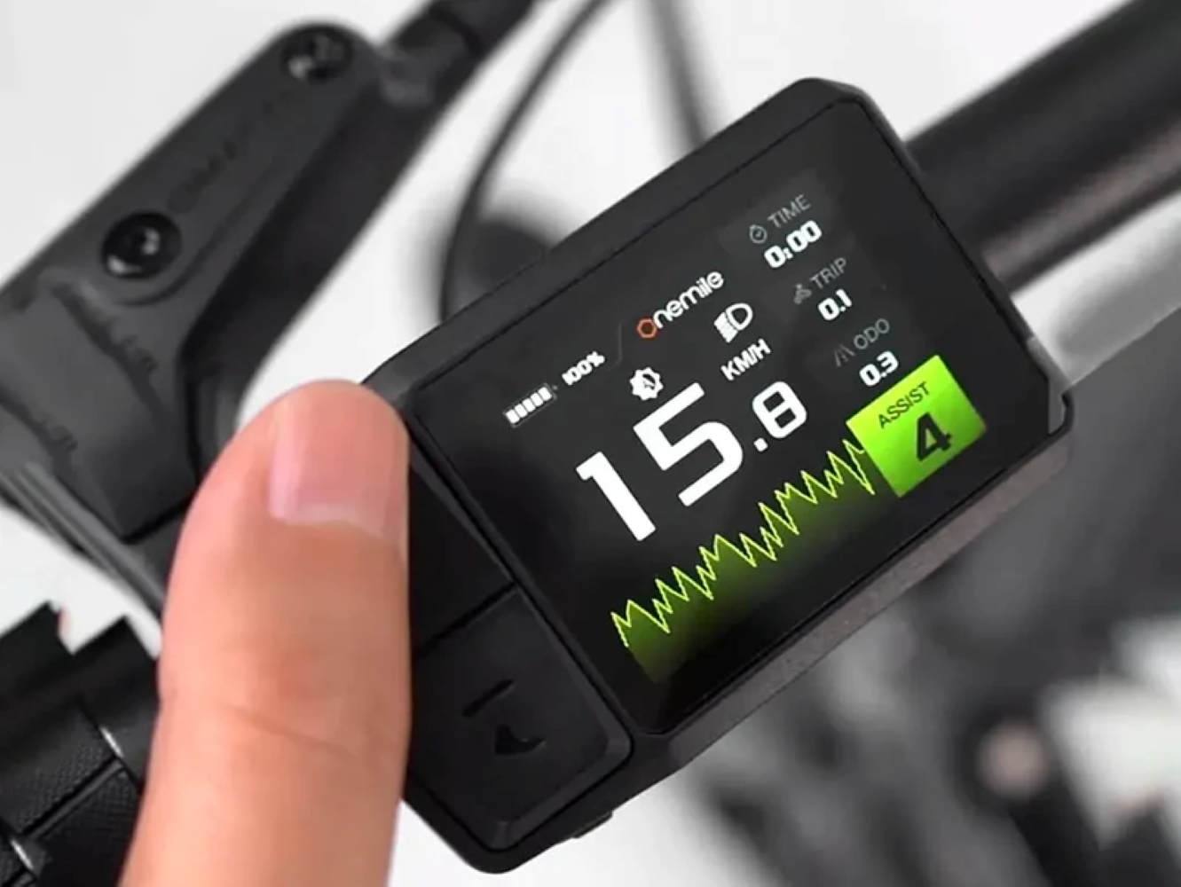 Un dedo toca la pantalla de una e-bike: 15,8 km/h, 100% batería, nivel 4.