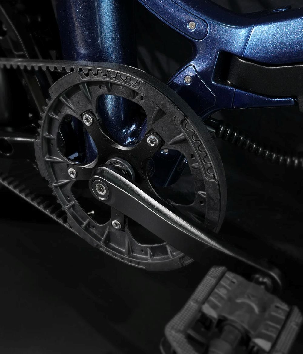 Primer plano del cuadro azul de bicicleta con plato, correa y pedal.