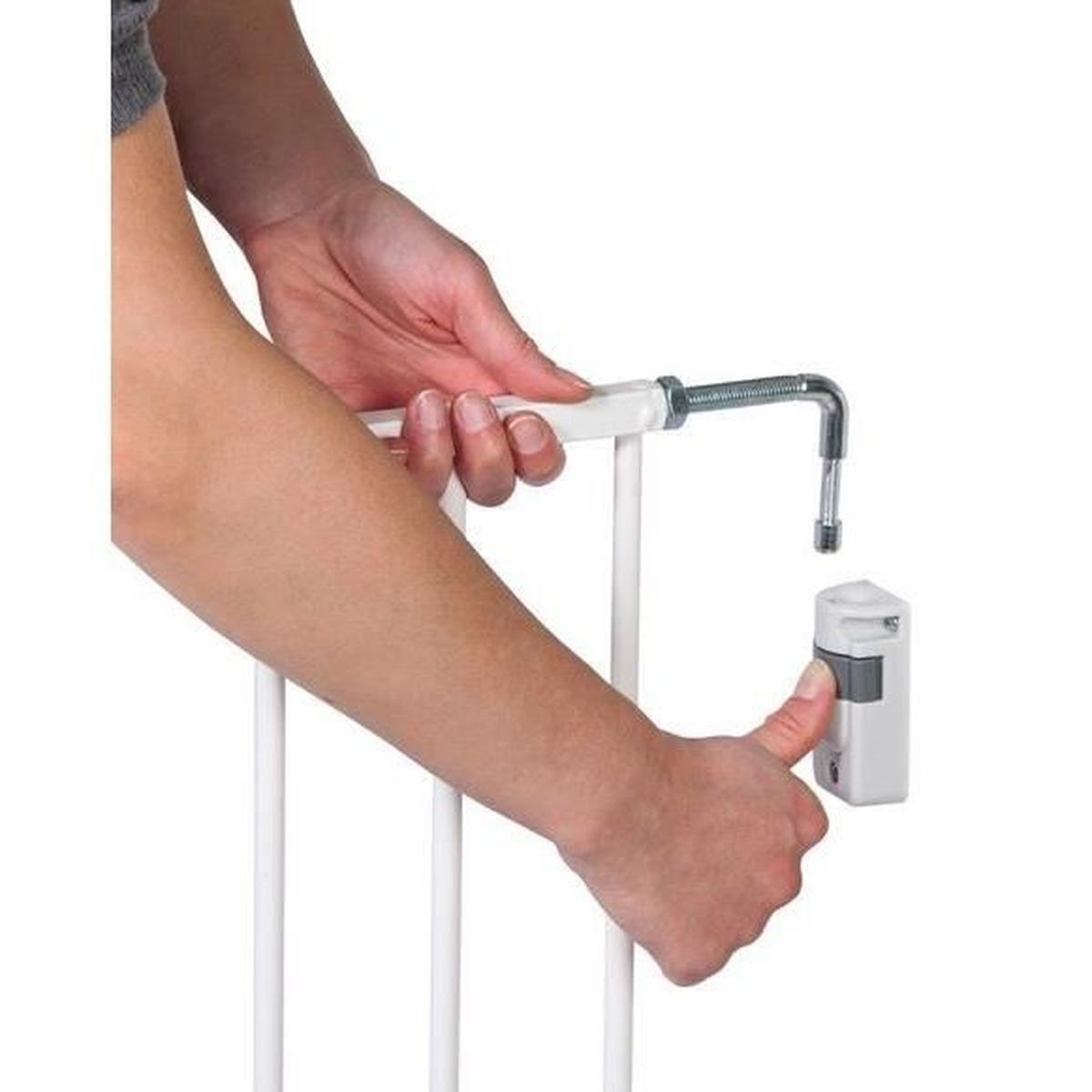 Una mano instala una puerta blanca con un perno metálico en un soporte de pared.