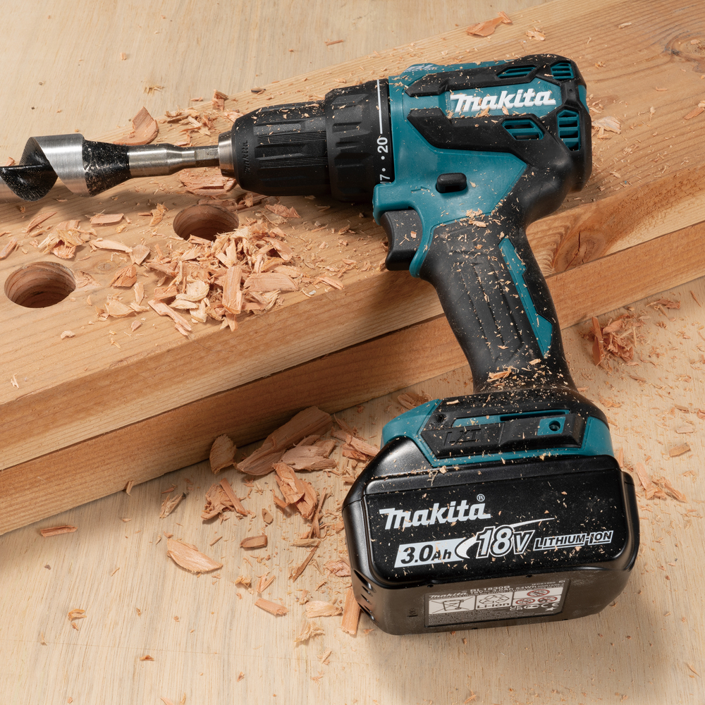 Un trapano a batteria Makita con una punta a vite è su una superficie di legno.
