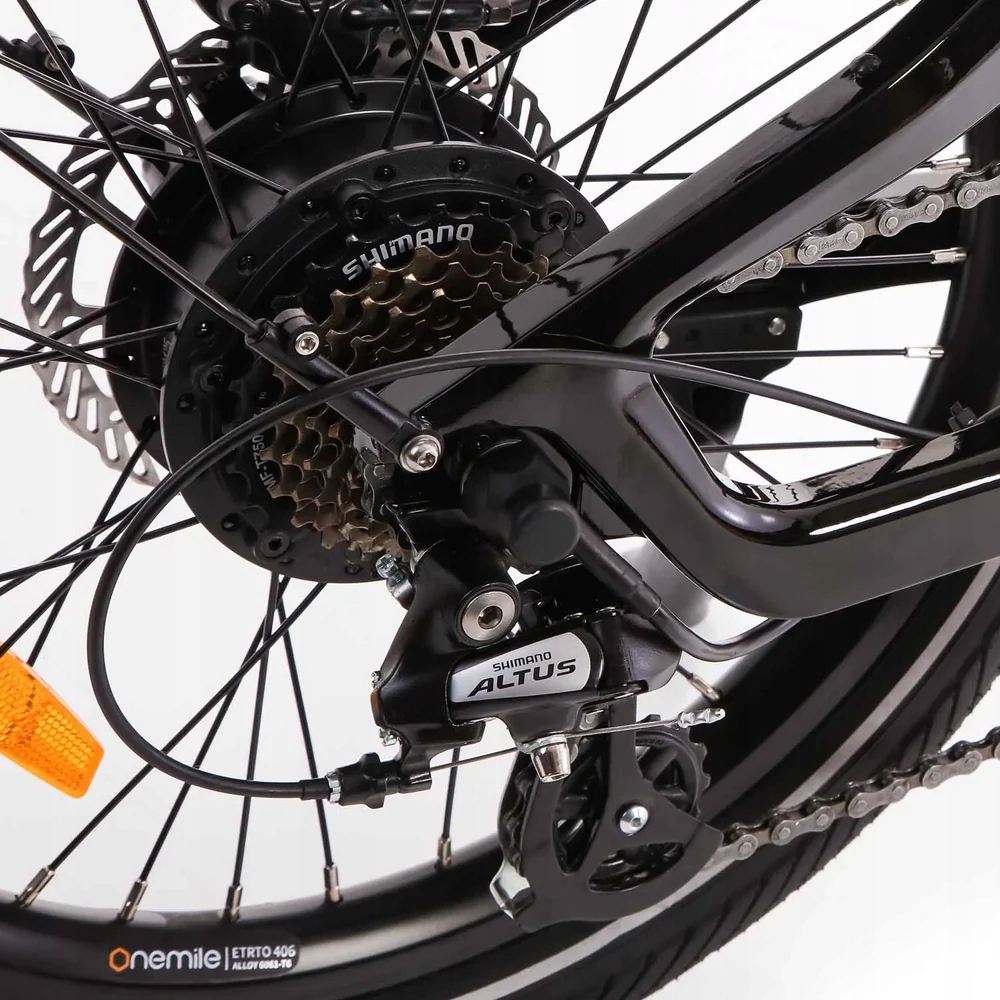 Primo piano di un deragliatore e cassetta di bicicletta neri con raggi e cerchio.