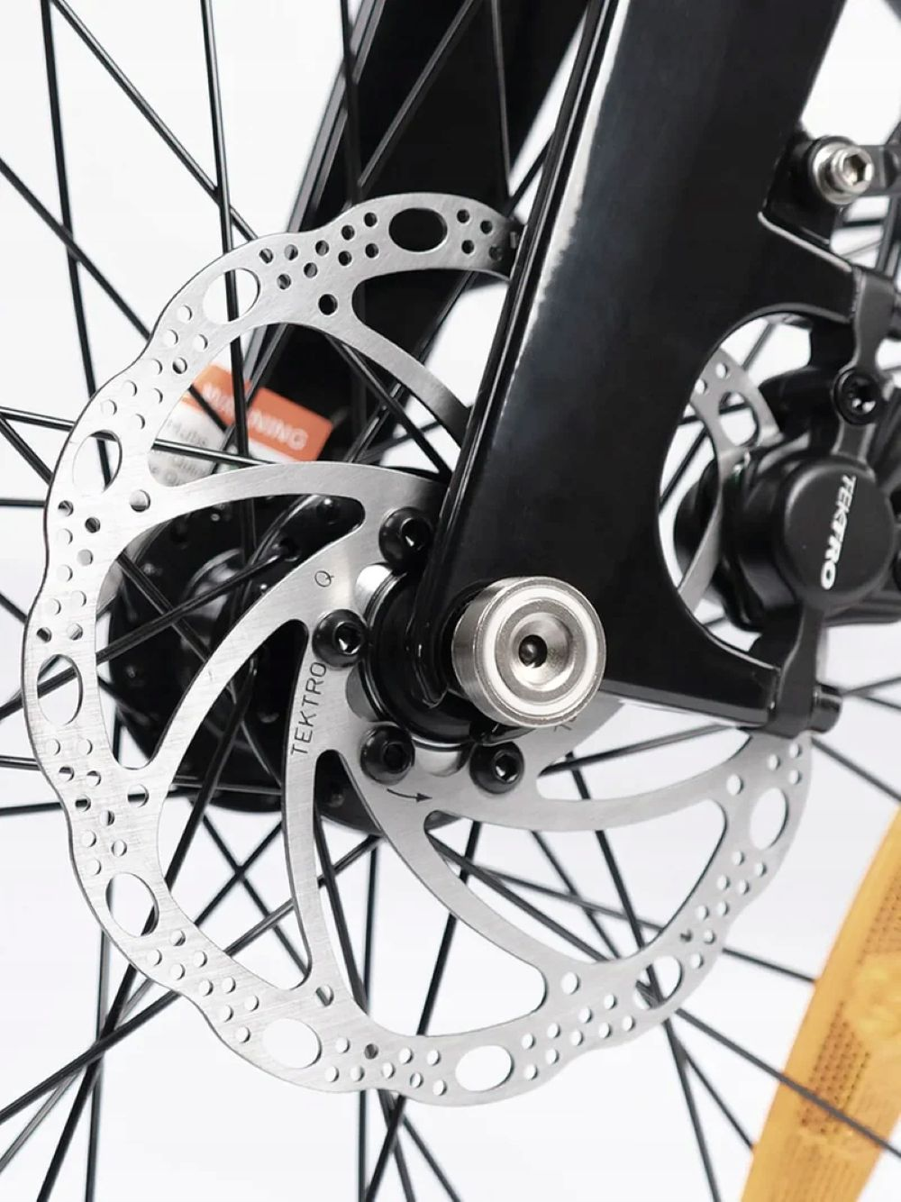 Primo piano di un freno a disco per bicicletta con rotore argentato e pinza nera.