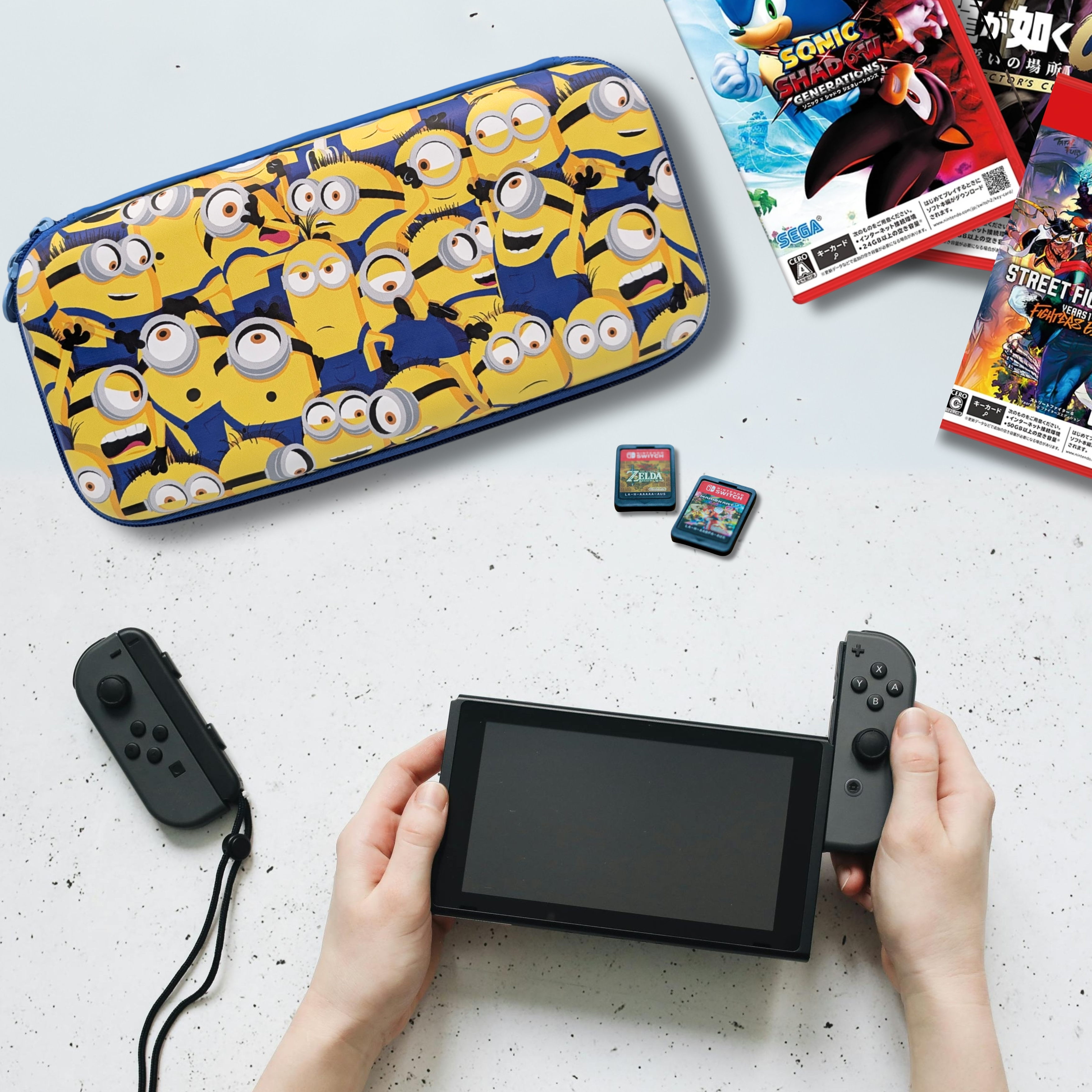 Una Nintendo Switch con funda de Minions, juegos y mando.