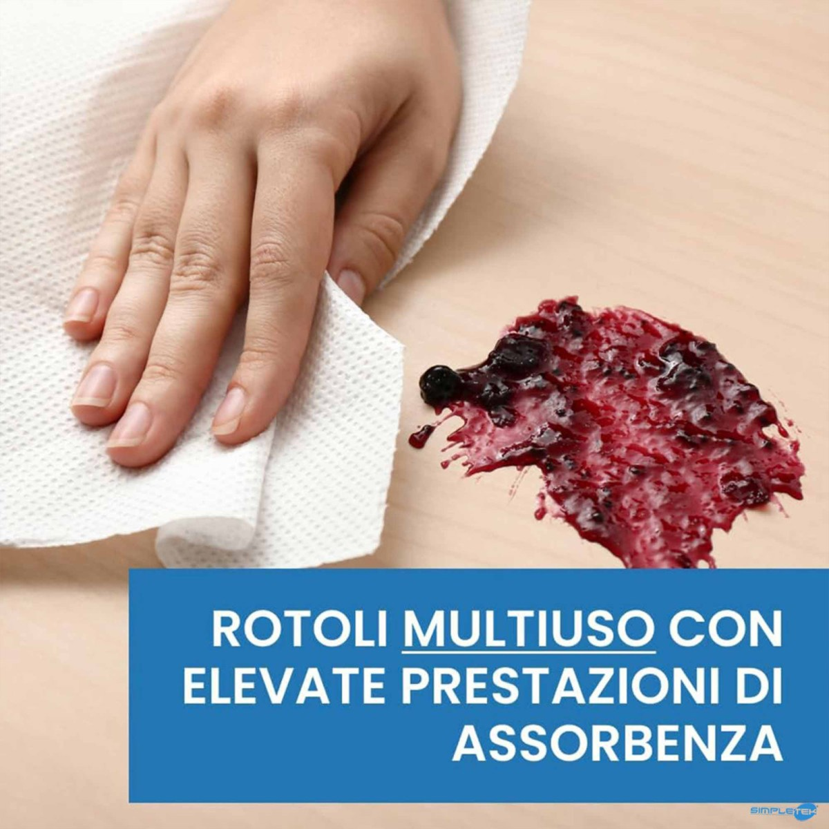 Una mano usa un tovagliolo di carta bianco per pulire una macchia di bacche rosse su un tavolo di legno.