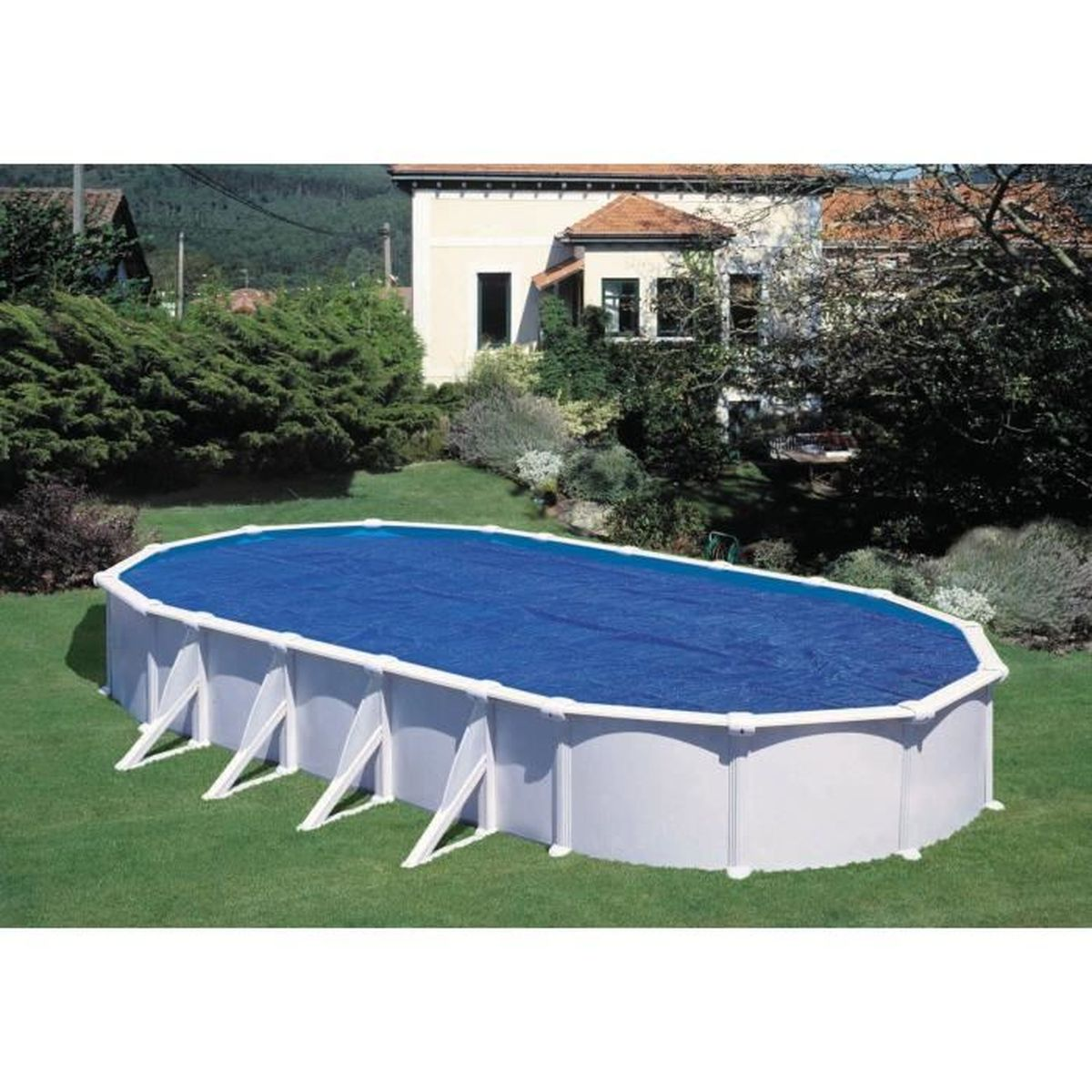 Piscina ovale fuori terra con copertura blu in giardino, casa dietro.