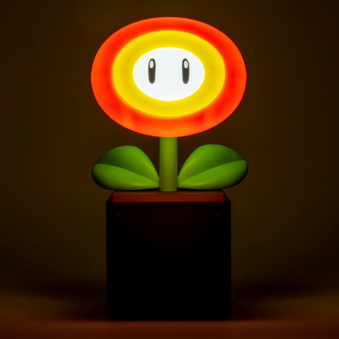 Une fleur lumineuse avec deux yeux et des feuilles vertes dans un pot rouge.