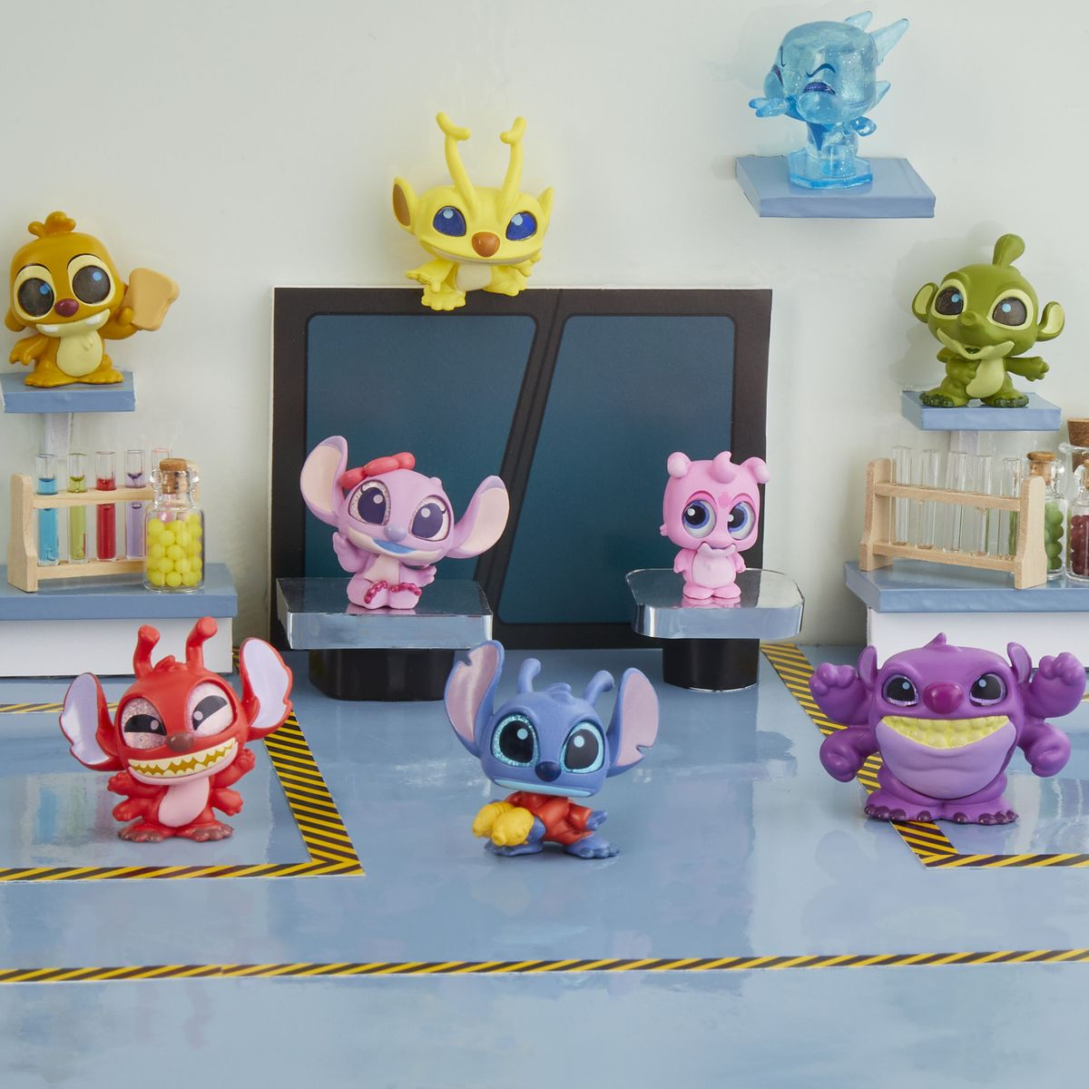 Escena de laboratorio con figuras coloridas de Stitch y tubos de ensayo.