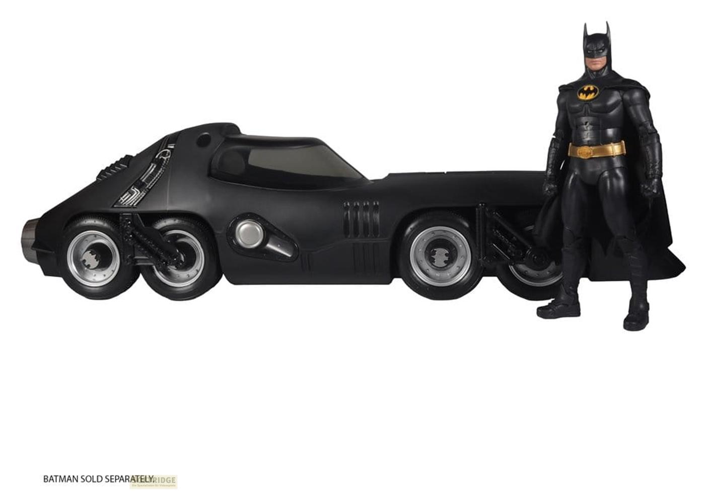Eine schwarze Batman-Figur steht neben einem schwarzen Batmobil mit drei Rädern vorn.