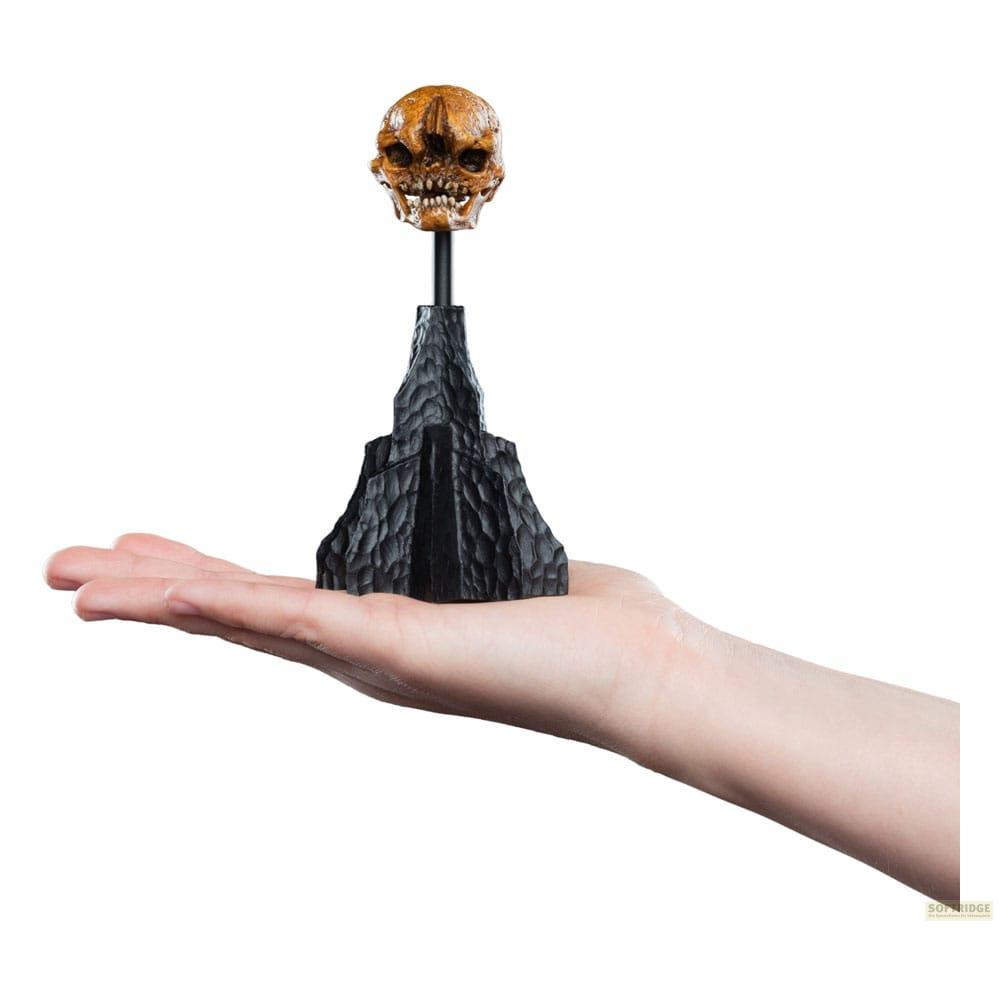 Eine Hand hält ein schwarzes Modell mit einem Totenkopf darauf.