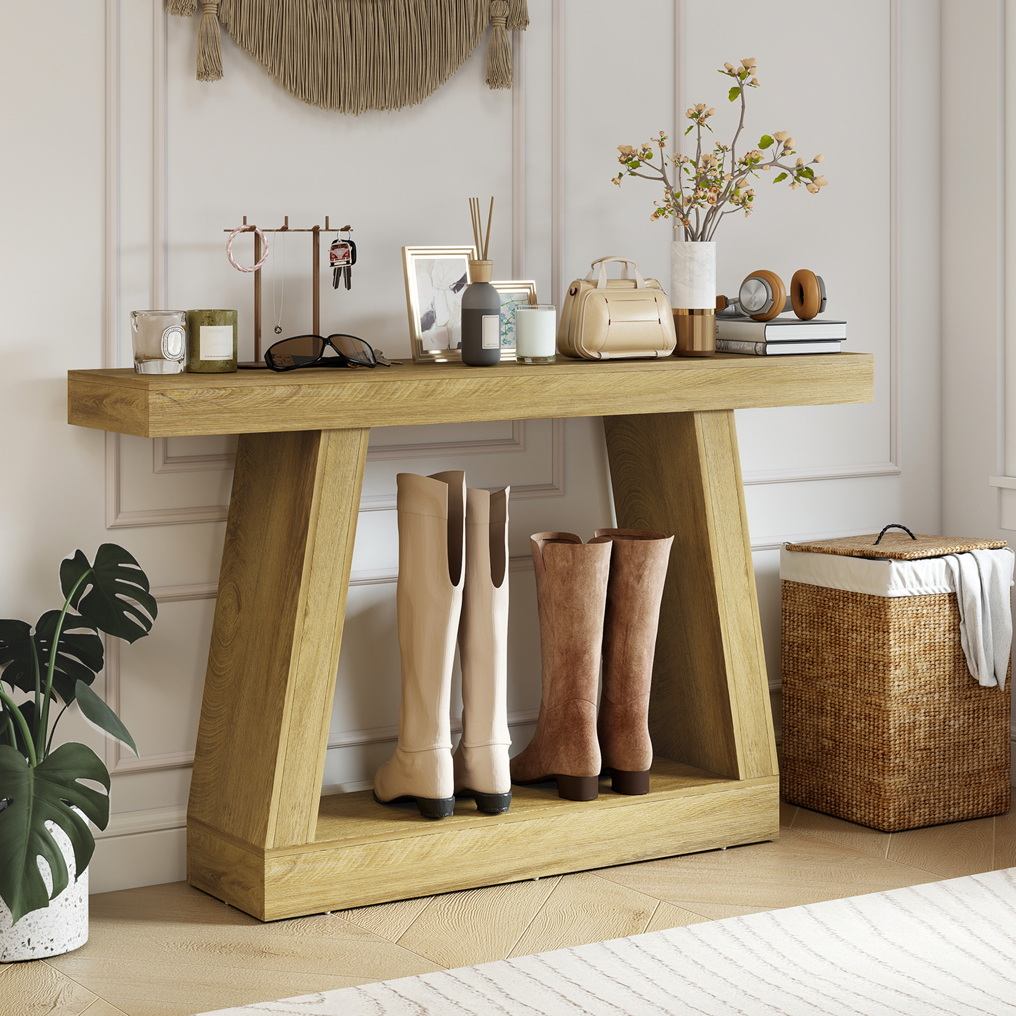 Un tavolino consolle in legno con stivali, candele, borsa e oggetti decorativi.