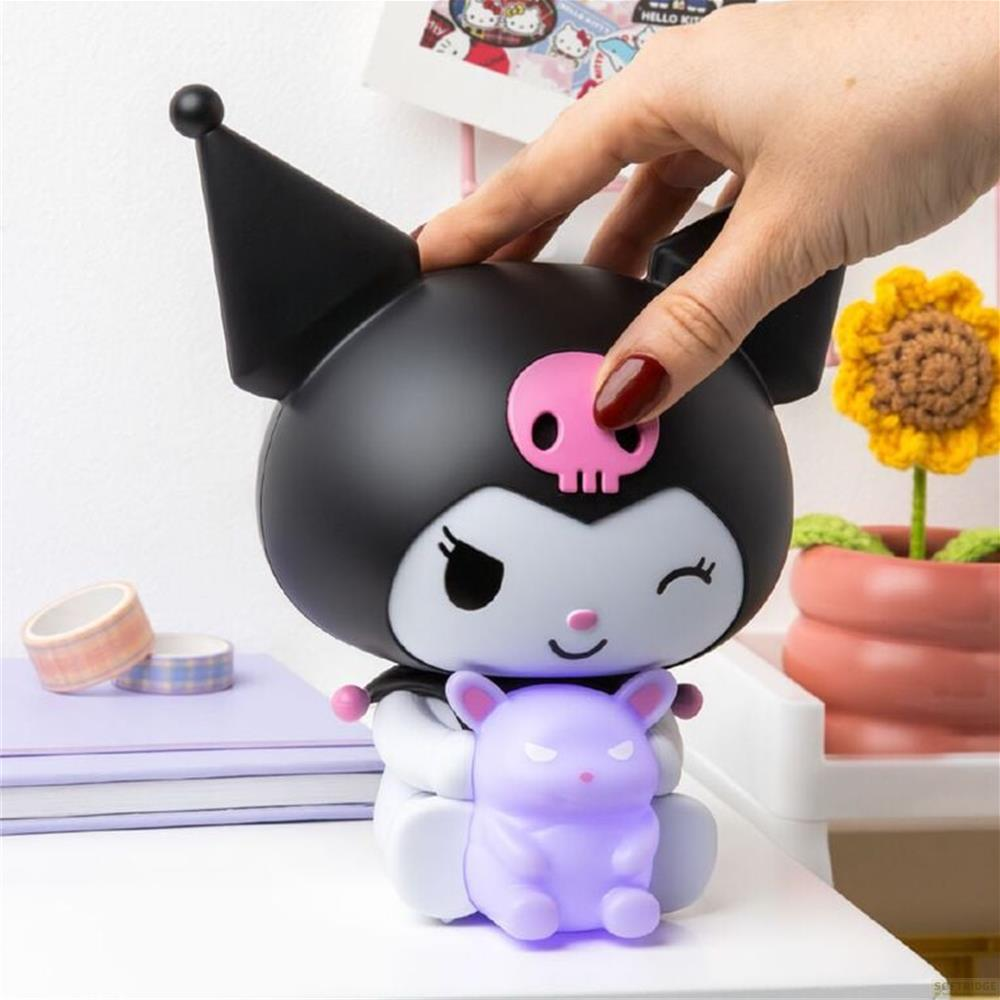 Figurka Kuromi trzyma fioletowego królika. Ręka dotyka głowy. Kaktusowy kwiat w doniczce obok.