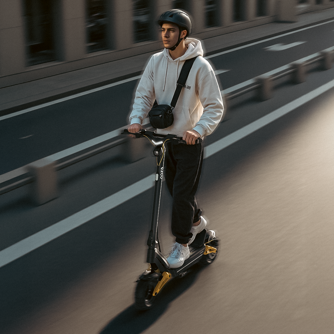 Uomo con casco guida monopattino nero su strada. Sfondo sfocato.