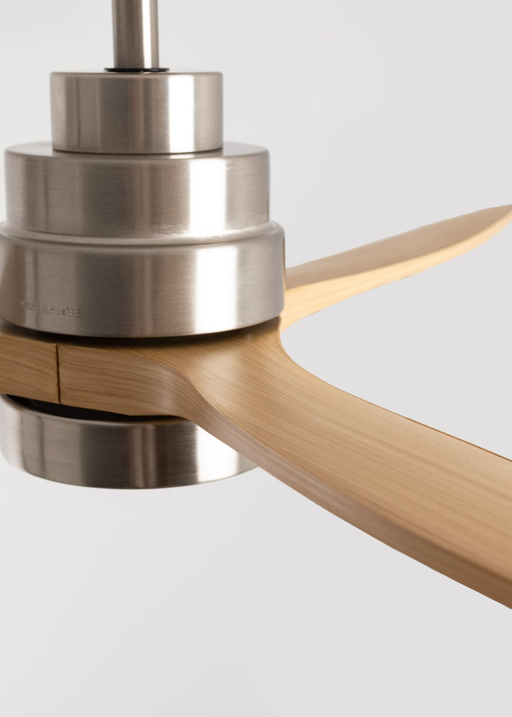 Un ventilador de techo con carcasa de metal y aspas de madera.