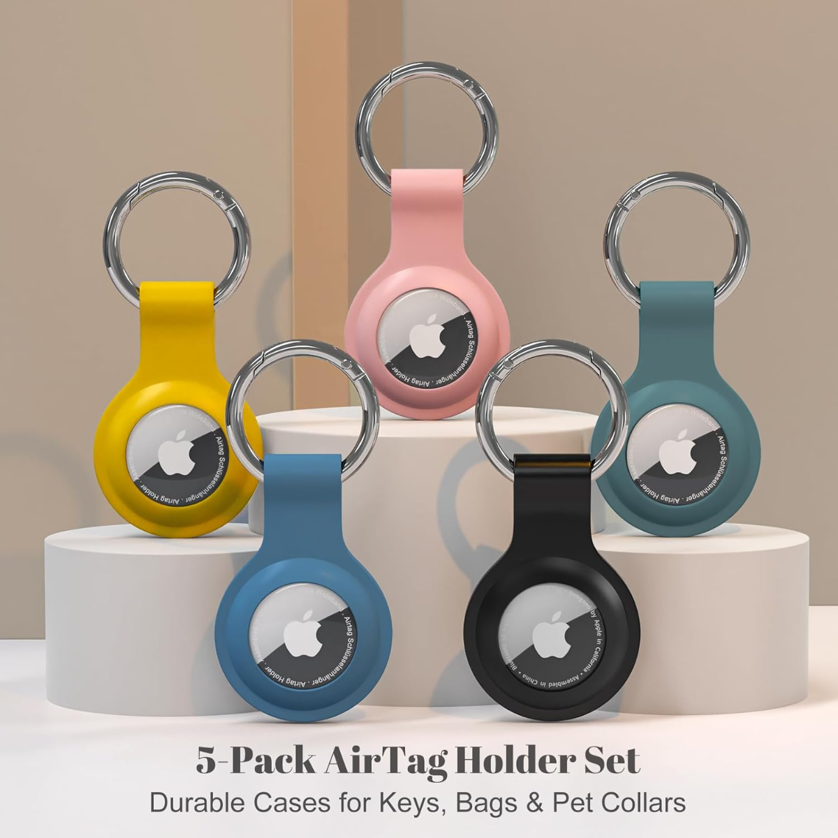 Cinco soportes AirTag en amarillo, rosa, azul, turquesa y negro con llaveros.
