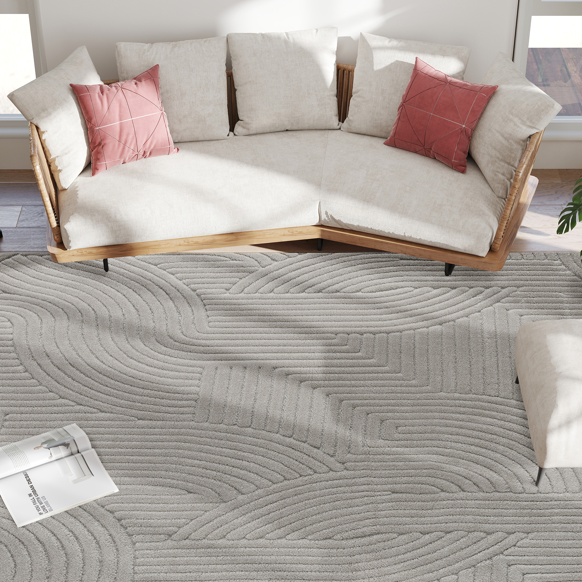 Un sofá claro con cojines grises y rosas sobre una alfombra gris.
