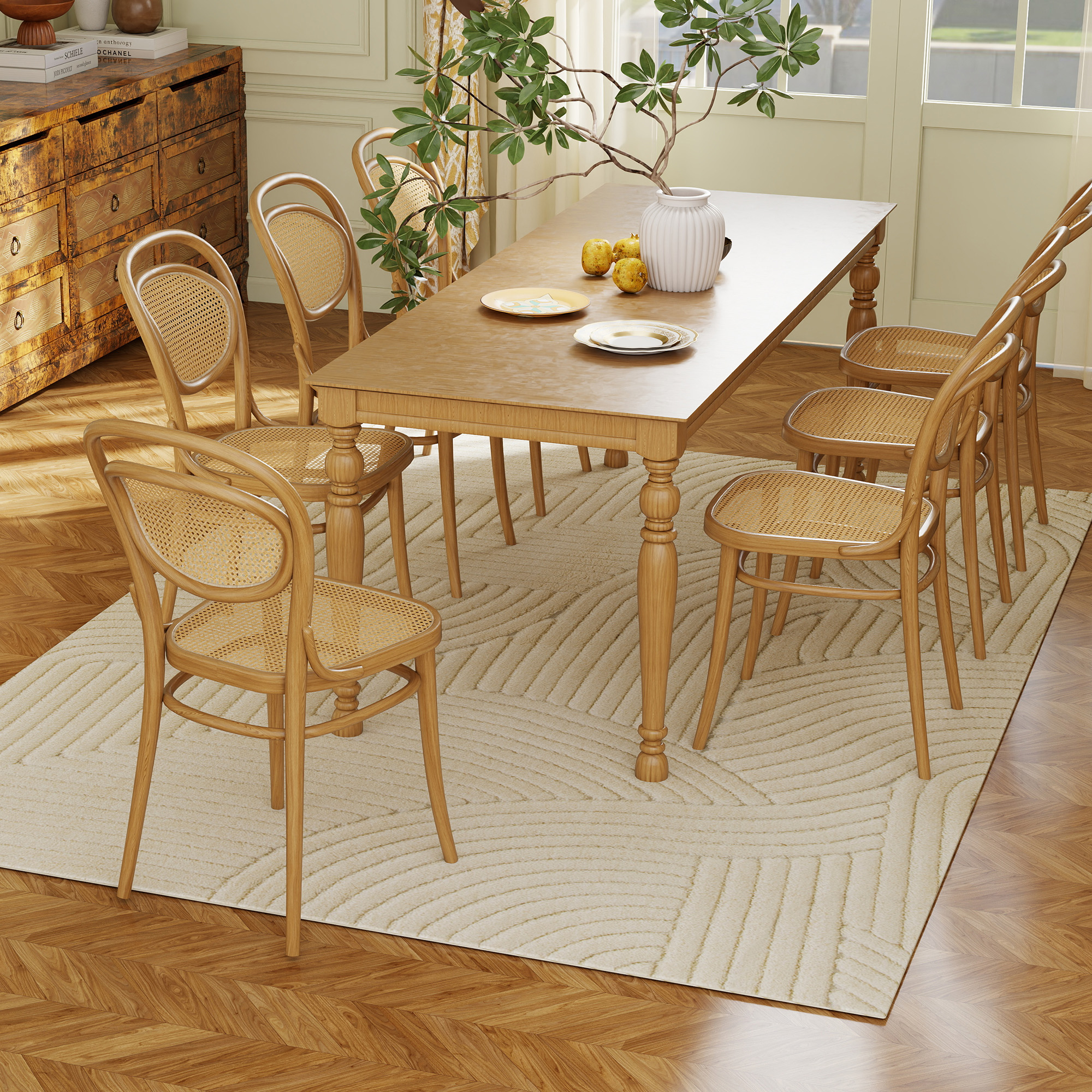 Un comedor con mesa de madera, sillas de ratán, alfombra y un mueble antiguo.