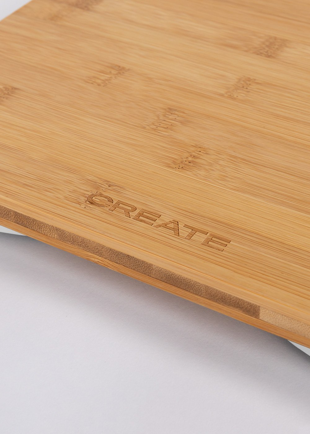 Primer plano de una tabla de cortar de bambú con la palabra CREATE.