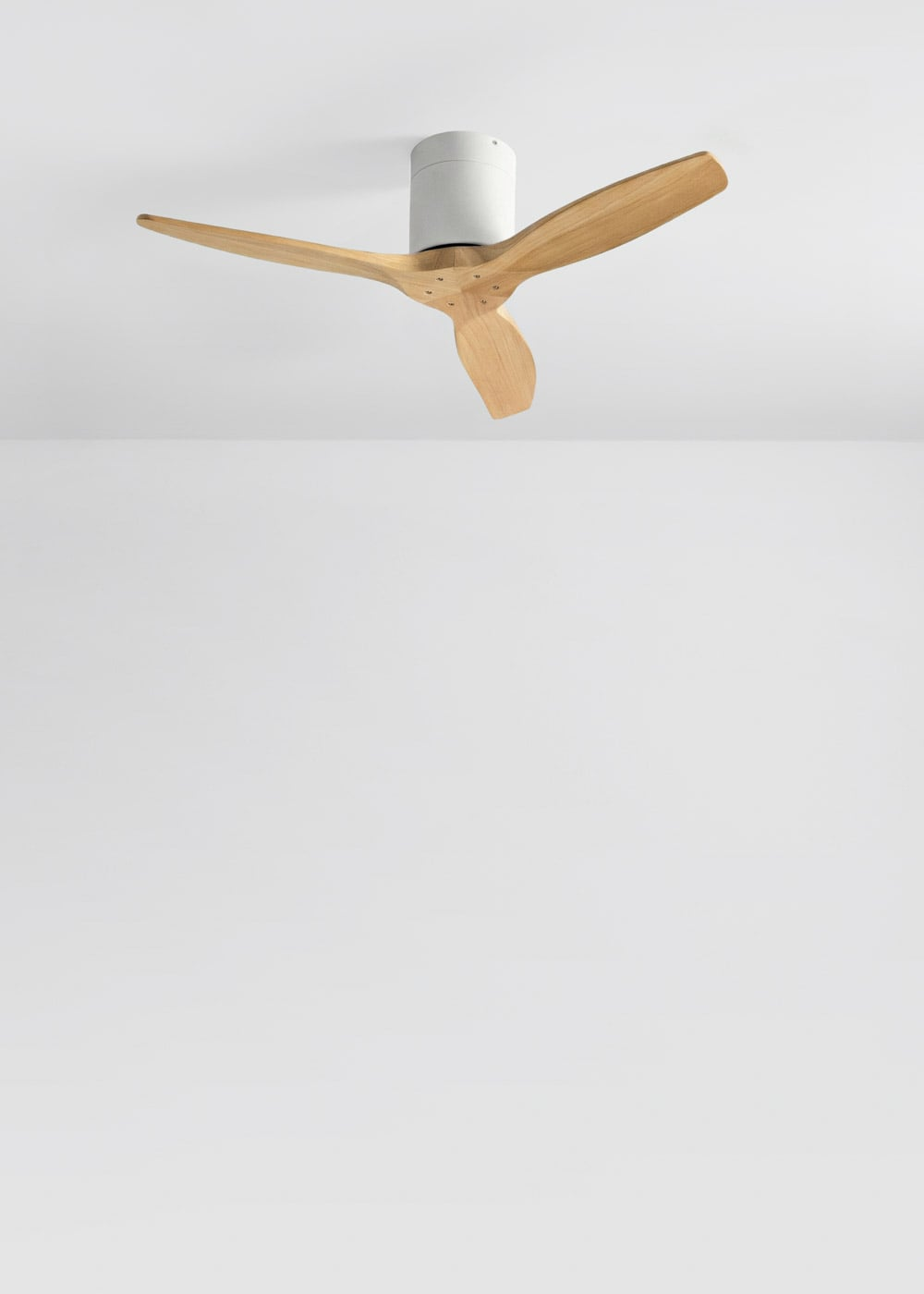 Un ventilador de techo con tres aspas de madera y carcasa blanca.