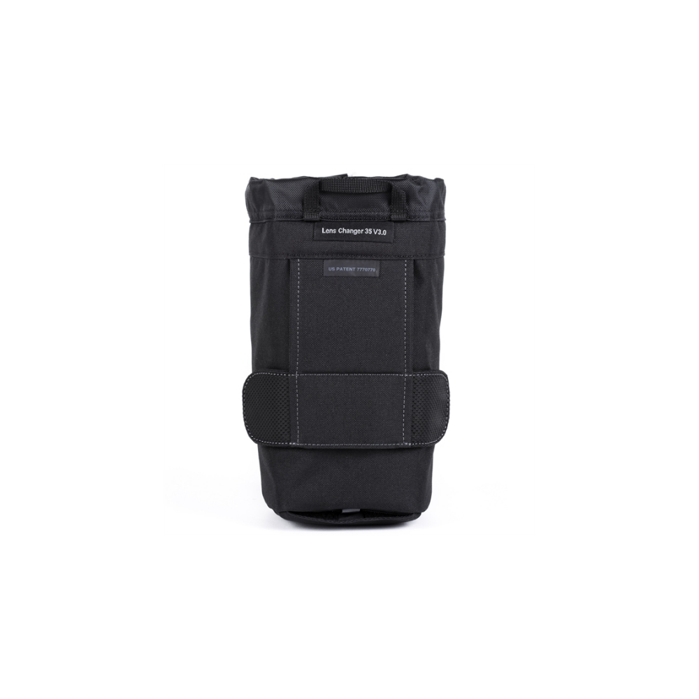 Een zwarte, verticale tas met trekkoord en klittenbandsluiting. Gelabeld 'Lens Changer 35 V3.0'.