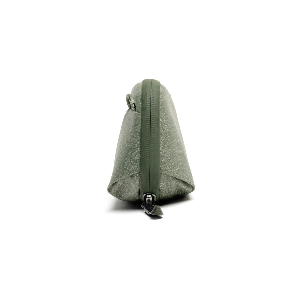 Een groene stoffen etui met rits op witte achtergrond.