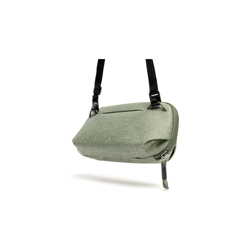 Groene crossbody tas met zwarte band en ritsdetail.