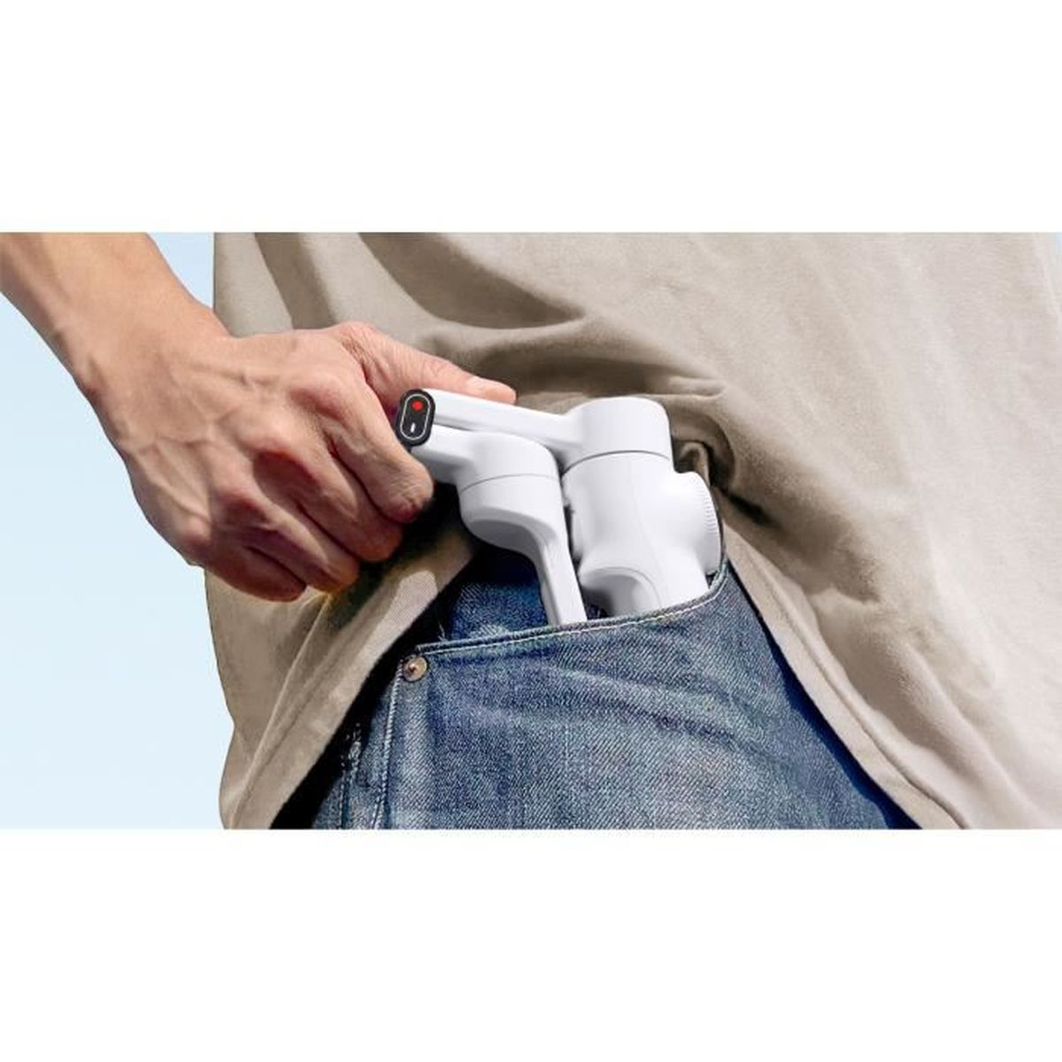 Eine Hand steckt einen weißen Gimbal in eine Jeanstasche.