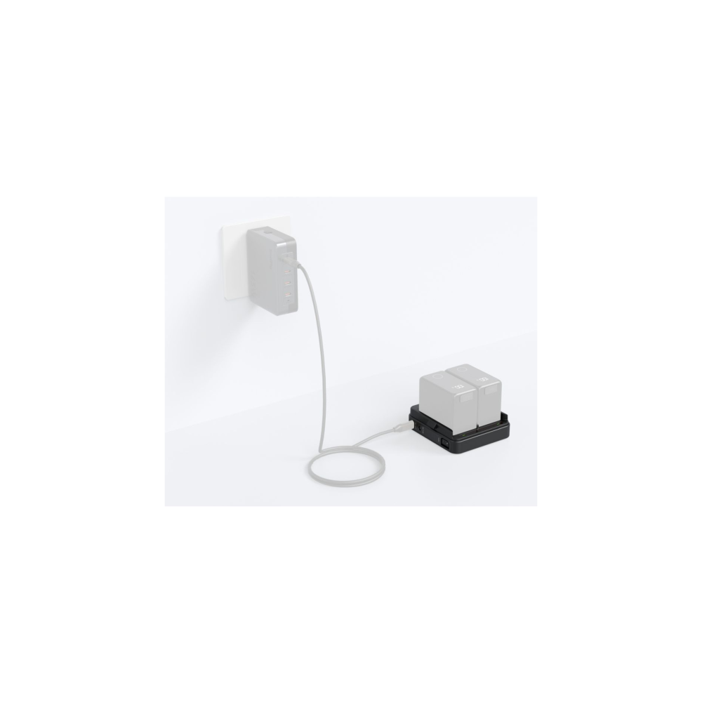 Oplader met twee batterijen en een oplaadkabel aangesloten op een stopcontact.