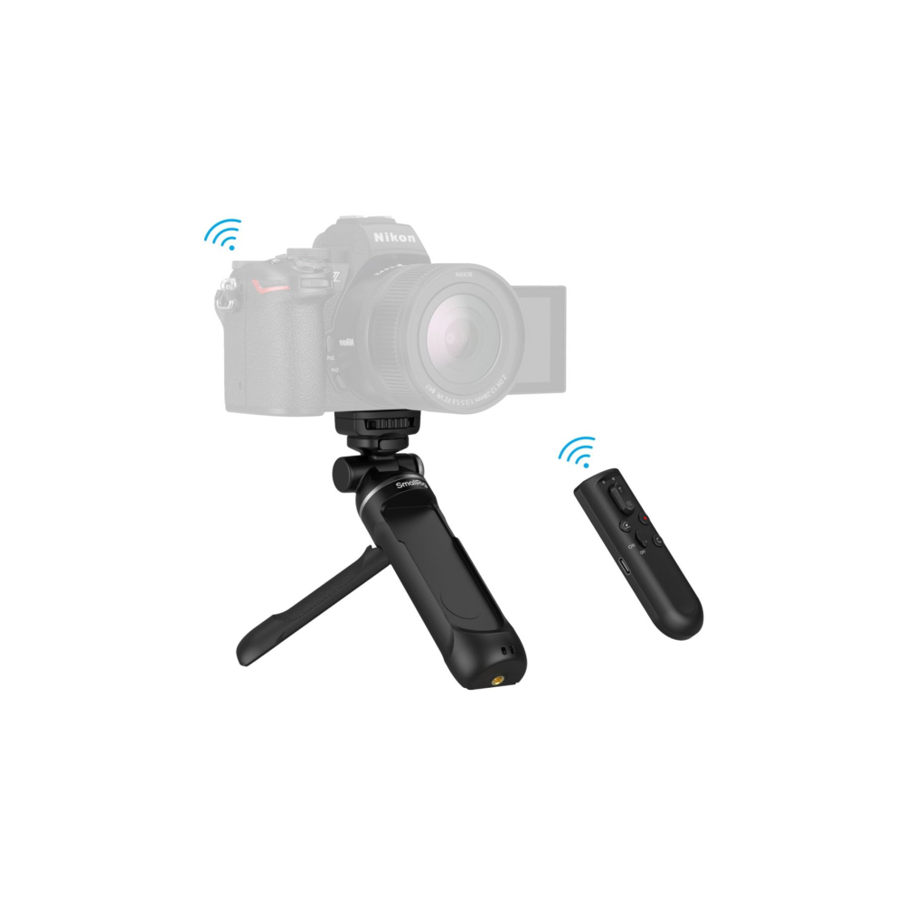 Una fotocamera Nikon grigia su un mini treppiede nero con telecomando.