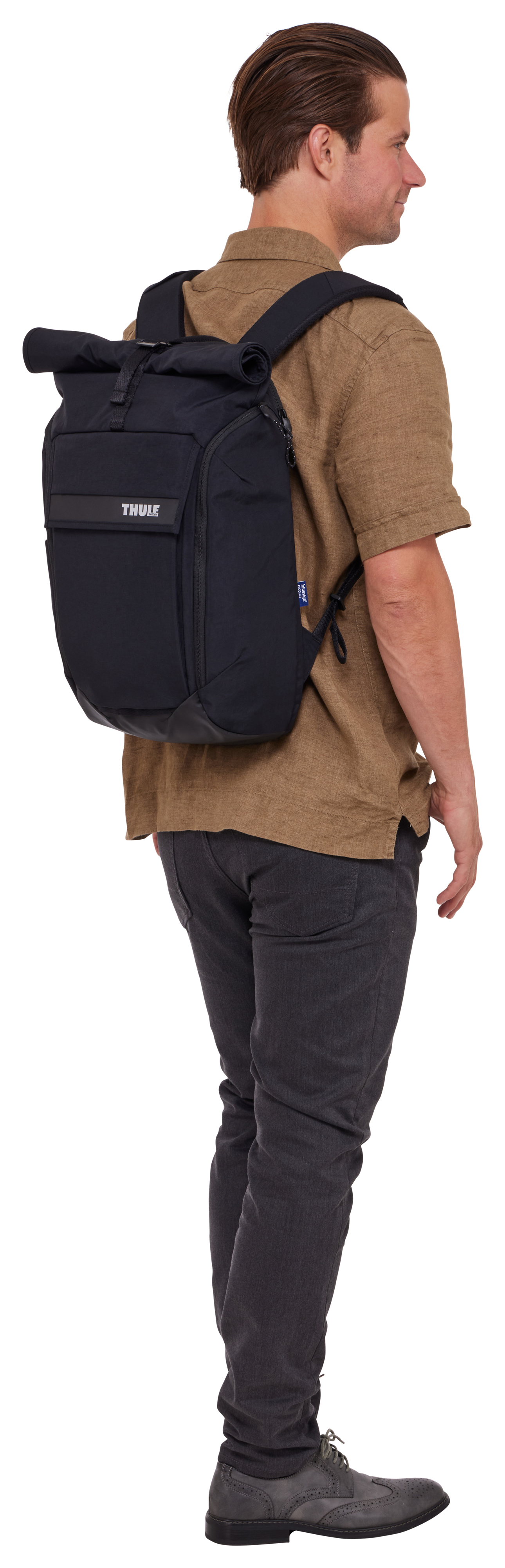 Mann mit schwarzem Rucksack und braunem Hemd.