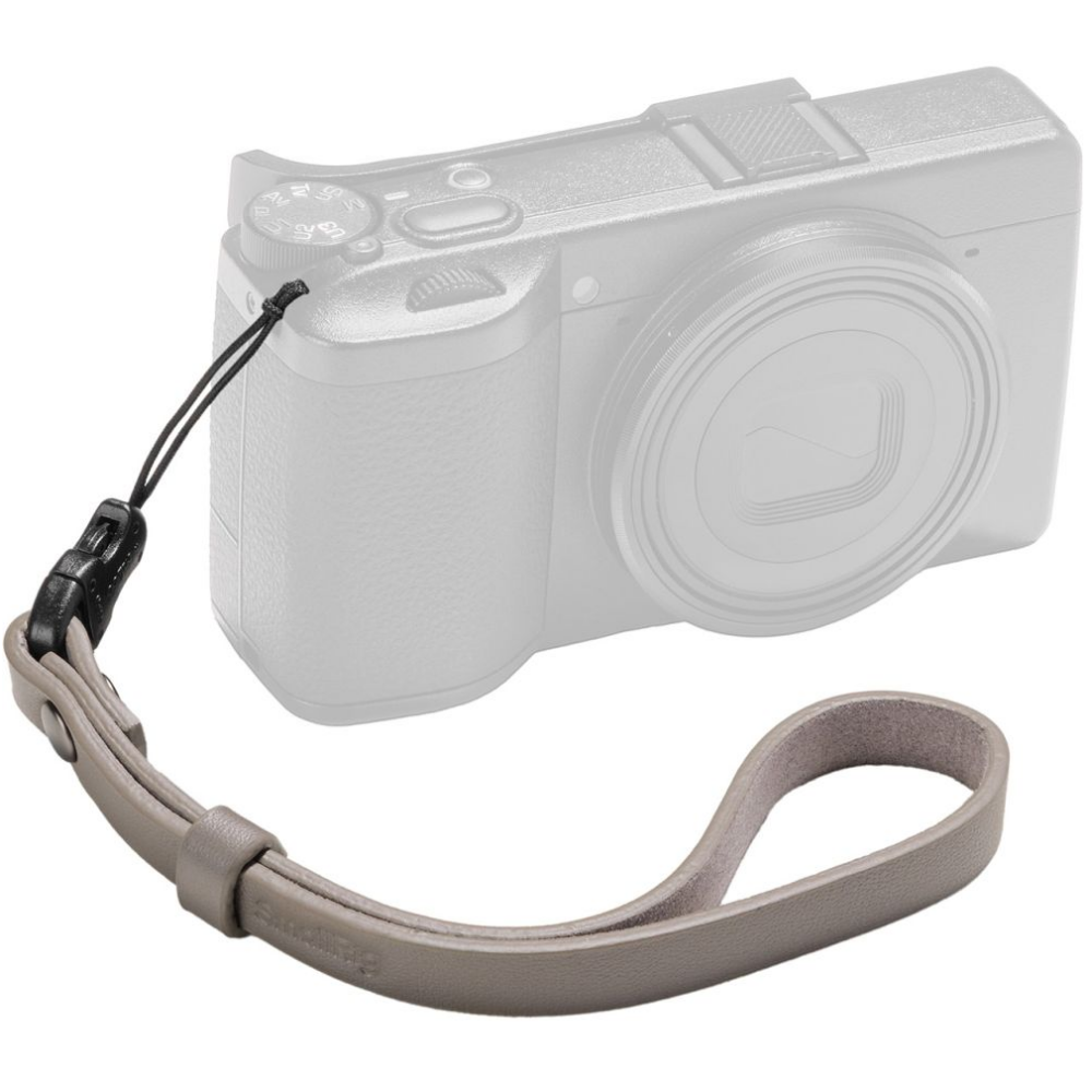 Grijze leren polsband voor camera met zwarte clip en koord, bevestigd aan een grijs camerabody.