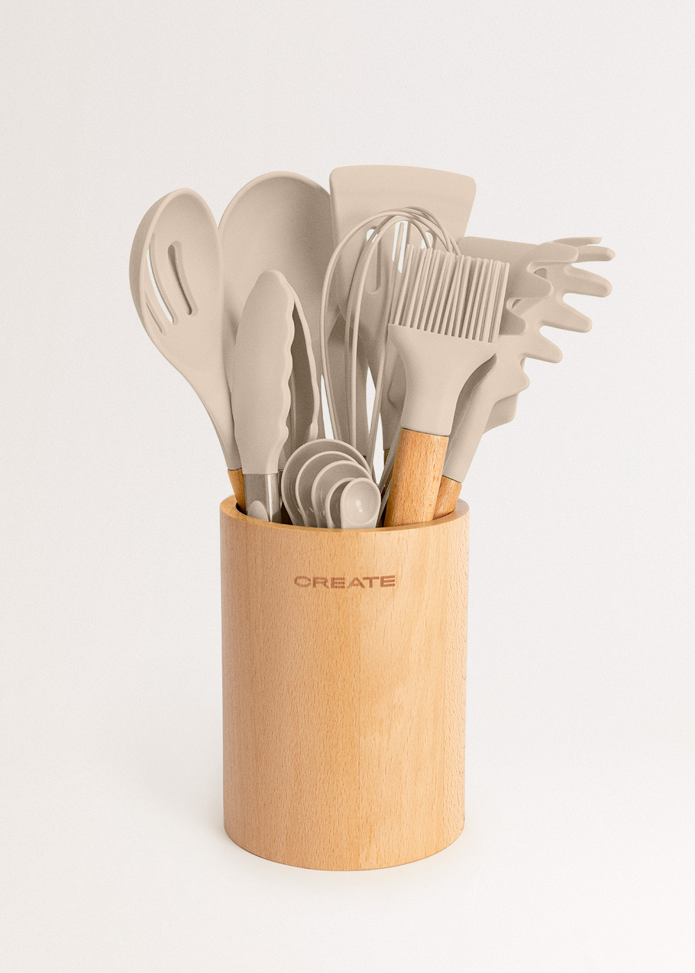 Utensilios de cocina beige en un soporte de madera con el logo CREATE.