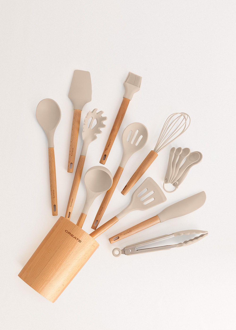 Una colección de utensilios de cocina de silicona beige con mangos de madera están dispuestos sobre una superficie blanca.