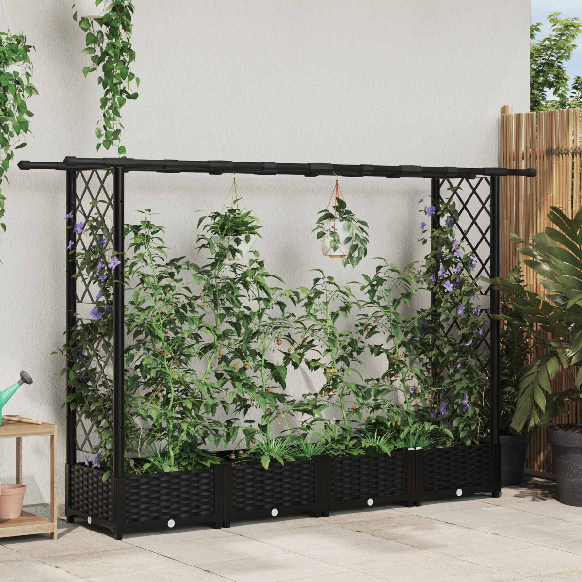 Ein schwarzer Rankgitter-Pflanzkasten mit verschiedenen Pflanzen und Blumen.