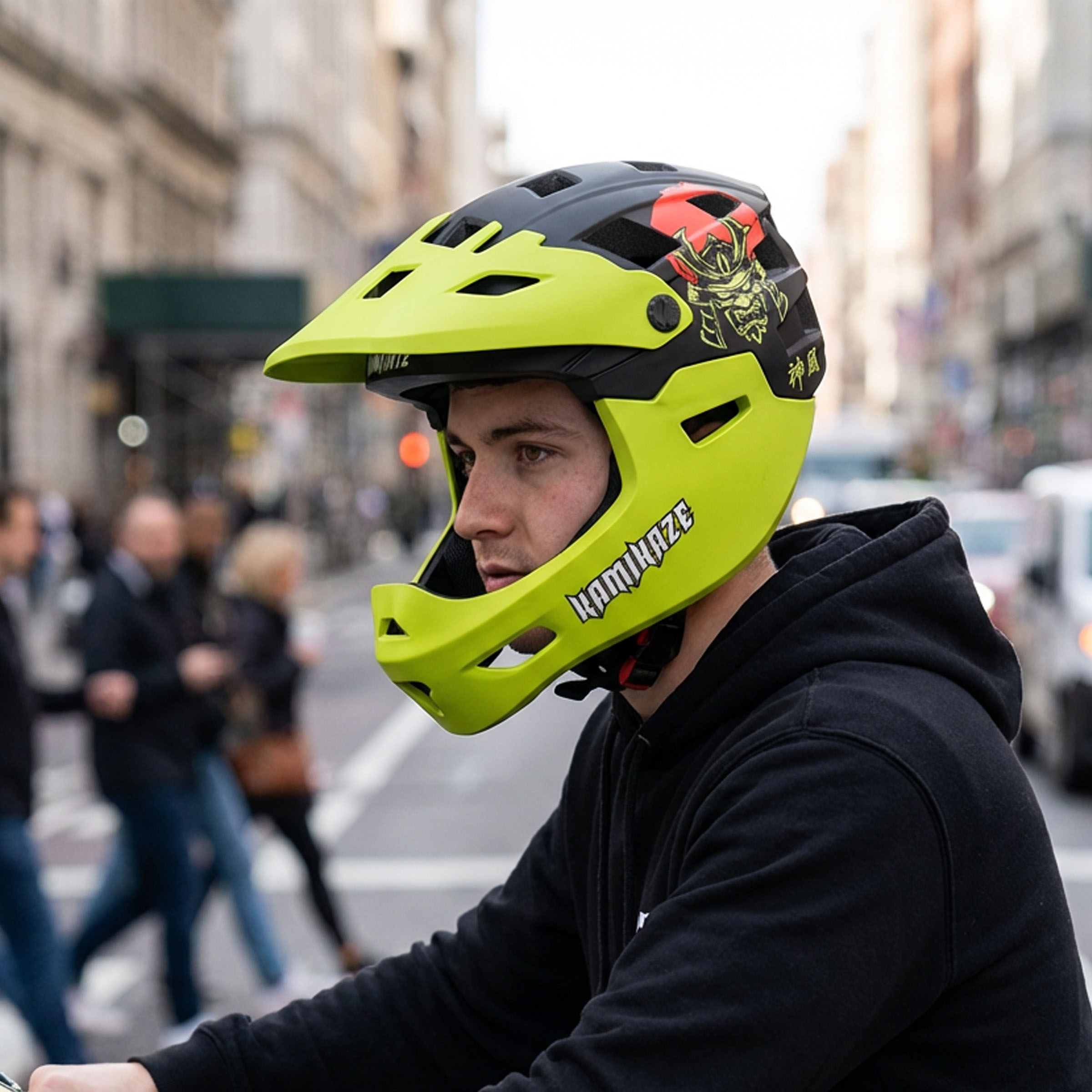 Un hombre lleva un casco amarillo brillante con gráficos negros y rojos en una calle.
