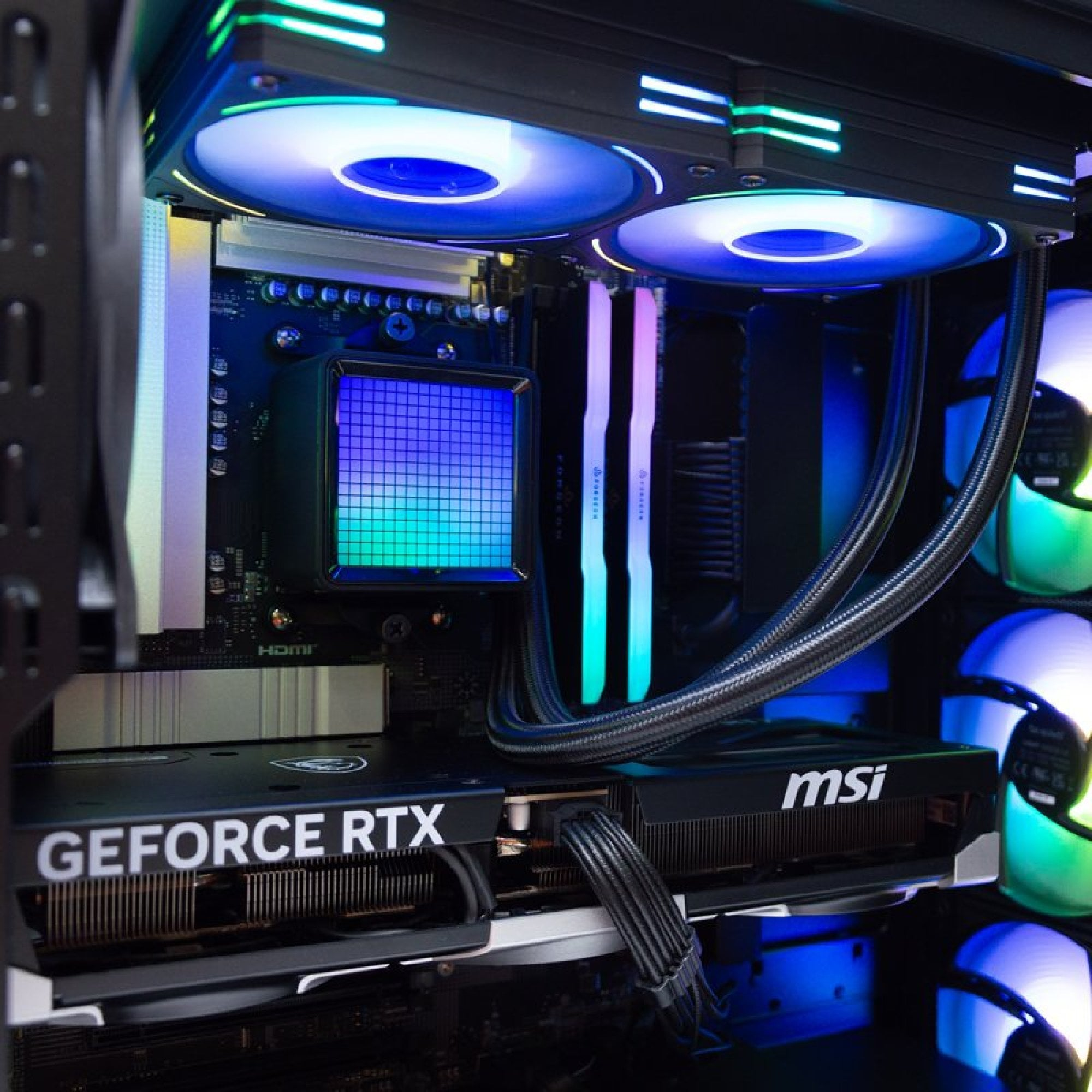 Interno di un case per computer, con luci RGB su ventole, RAM e dissipatore CPU.