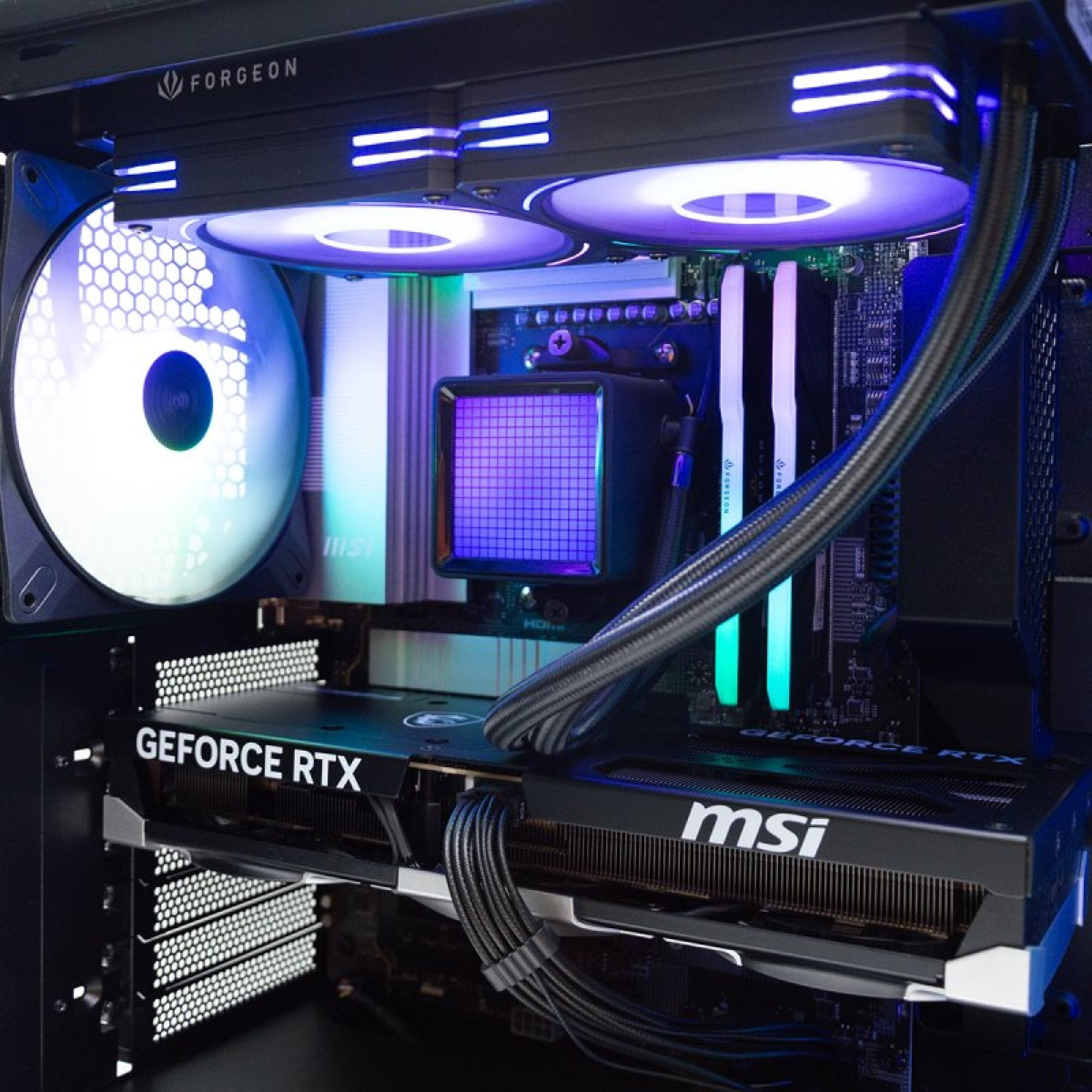 Interno di un case PC: ventole RGB, GPU, RAM e dissipatore a liquido con display viola.