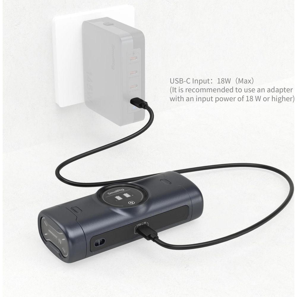Ein dunkles Ladeaccessoire ist über USB-C mit einem weißen Netzteil verbunden.